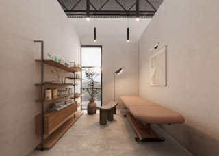Contemporary beauty salon treatment room with massage bed, wooden shelves, skincare products, and soft ambient lighting.