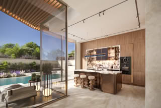 Modern kitchen with marble island, wood cabinets, and outdoor view of pool garden.