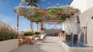A modern rooftop patio with a pergola, water feature, and outdoor seating under clear sky.