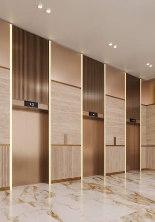 Modern elevator lobby with marble floors and gold accents.